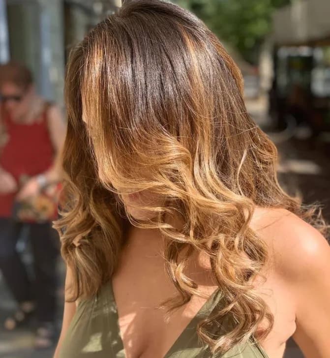 Capelli lunghi ondulati, castano con schiariture color caramello